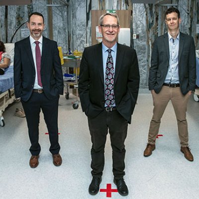 Professor Trent Munro, Professor Paul Young and Assistant Professor Keith Chappell stand in the clinic with the first participants of the Phase I clinical trial of the UQ COVID-19 vaccine.